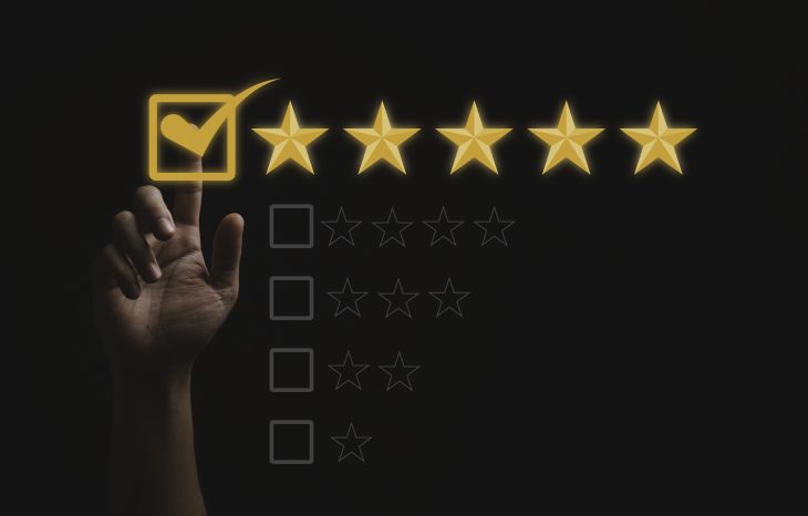 hand ticking a box with five yellow stars